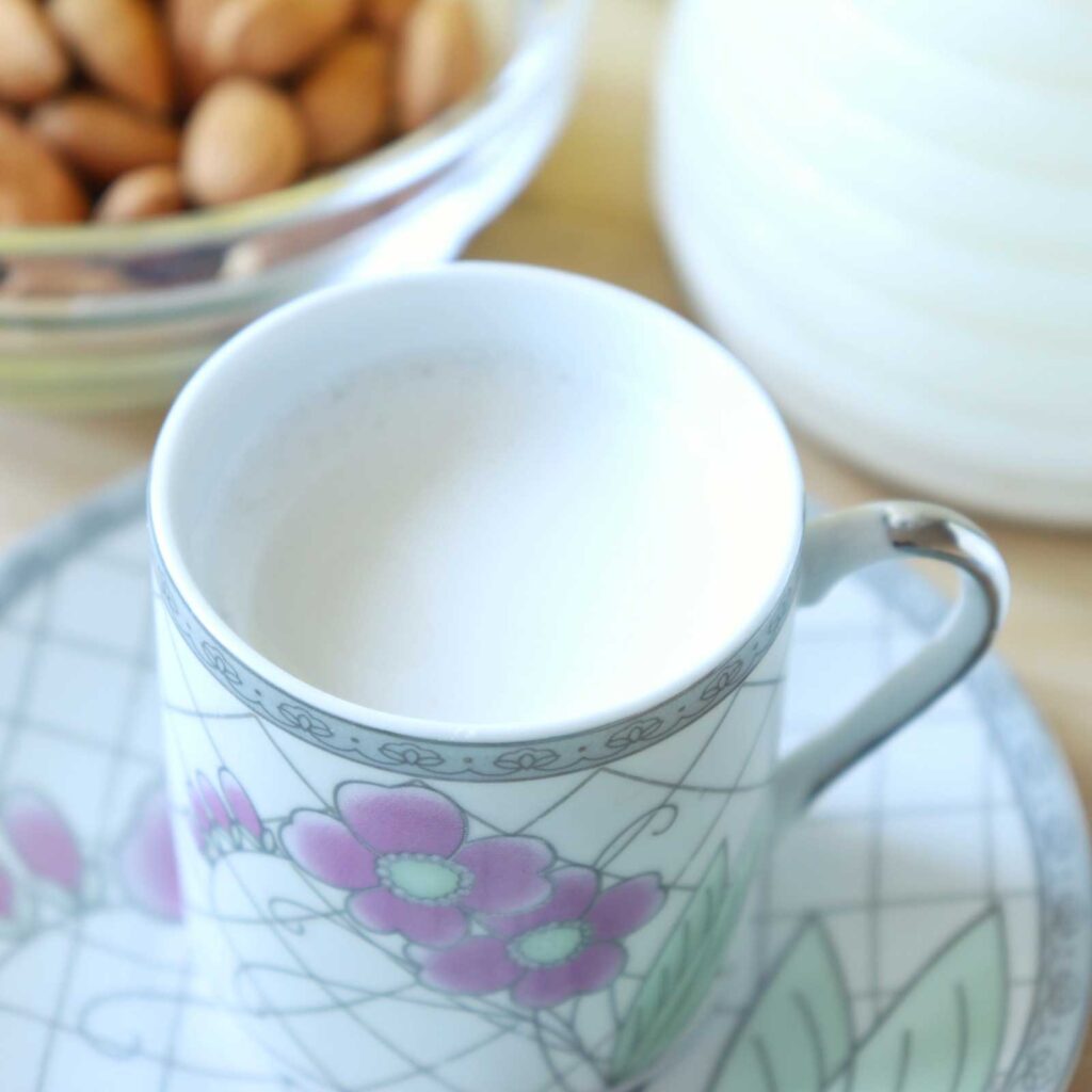 Step-by-step of how to make almond milk. Delicious fresh vegan milk in a cup. Easy to make recipe.