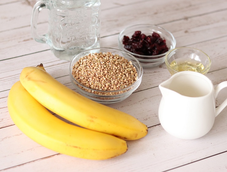 Toasted buckwheat groats with ingredients for making porridge: bananas, plant-based milk, agave syrup, dried cranberries and water.