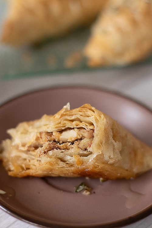 A piece of fresh baklava garnished with chopped nuts
