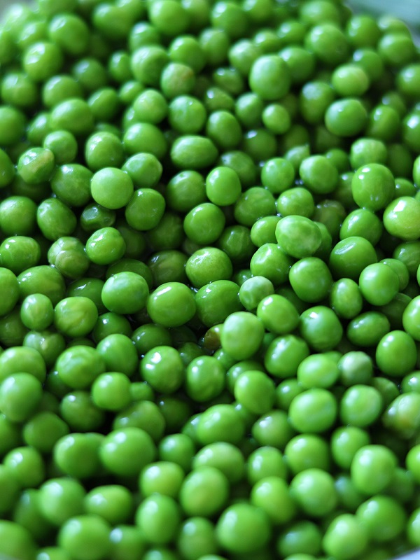 Frozen bright green peas ready to be cooked in a pea stew with vegetables for lunch or dinner