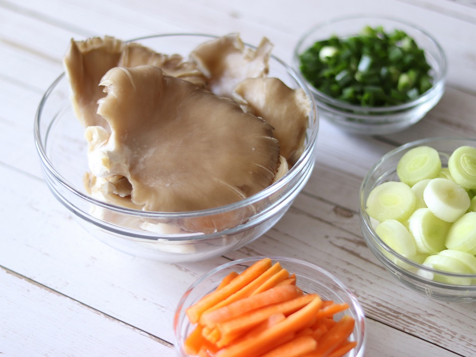 Healthy wholesome ingredients (oyster mushrooms, carrots, leek, green onions) for preparing oyster mushroom recipe as easy vegan lunch, side dish or dinner