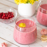 Cranberry banana raspberry creamy smoothie recipe decorated with yellow flower