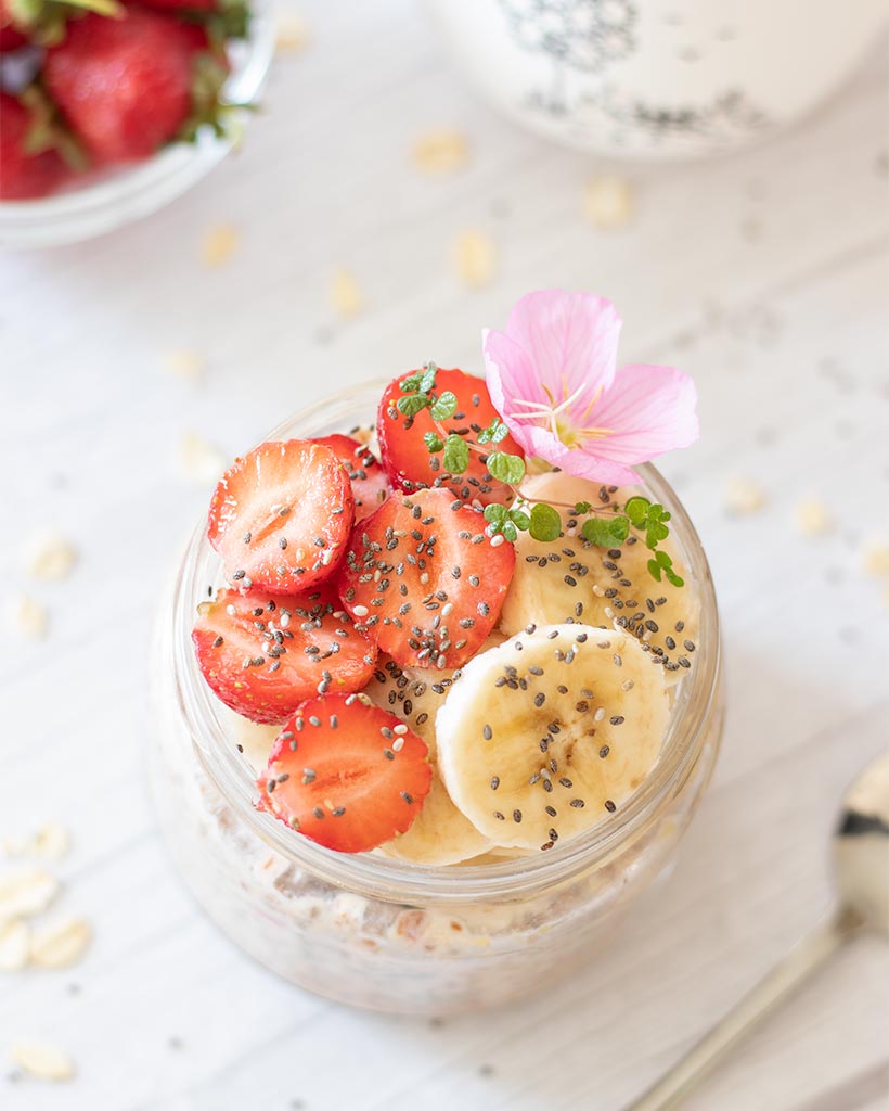 Healthy snack with strawberries, banana, oats and seeds