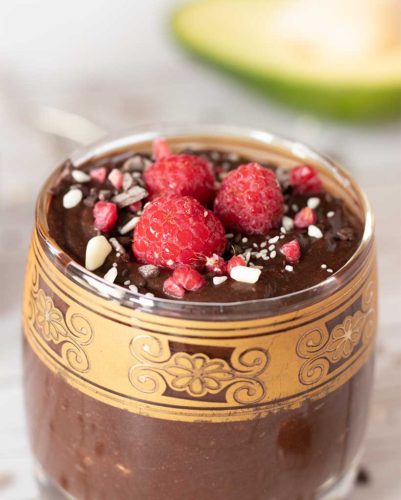 A closeup of clean dessert, vegetarian and vegan friendly. Homemade chocolate pudding with raspberries topping.