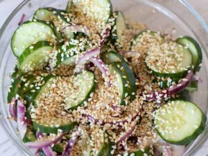 Toasted sesame seeds sprinkled on delicious and crunchy cucumber salad with vinegar.