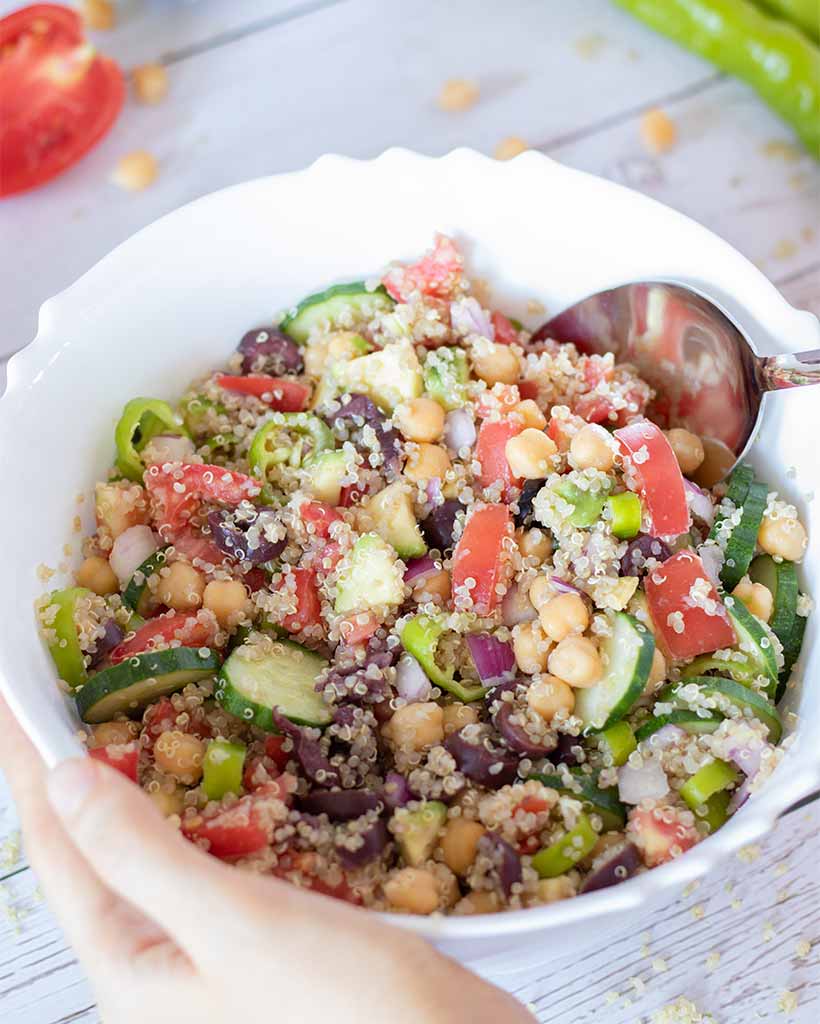 Mediterranean quinoa salad with chickpeas and various colorful veggies (cucumber, tomatoes, red onion, avocado and olives) drizzled with simple olive oil-mustard dressing.