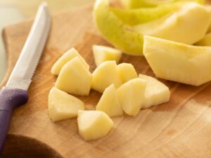 chopped green apples on wooden cupboard