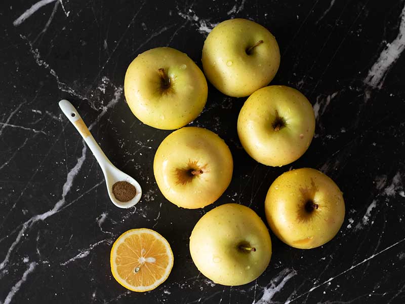 Plant-based, wholesome, simple ingredients for cookies applesauce at home: Golden Delicious apples, fresh lemon and ground cinnamon.