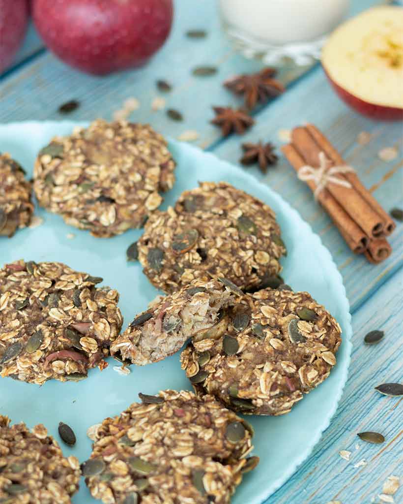 Soft and chewy apple oatmeal cookies with cinnamon on plate with blue wooden table for a healthy breakfast.