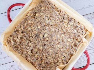 A base for an almond pulp cake in a small pan lined with parchment paper.