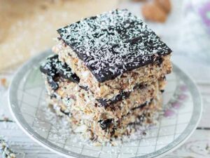 A stack of wholesome, chocolate almond pulp cake topped with coconut flakes.
