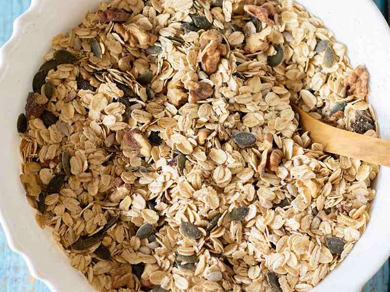 Dry ingredients mixed in a big bowl for preparing easy homemade granola recipe at home.