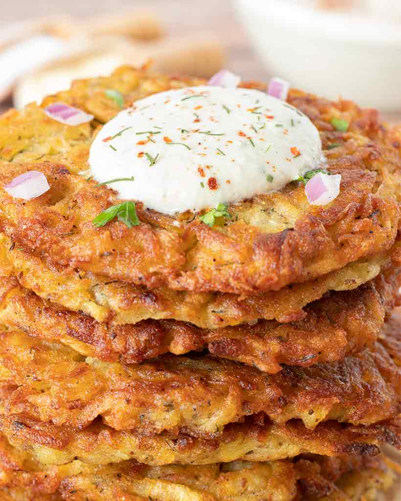 A stack of healthy, gluten-free potato pancakes without eggs and dairy topped with creamy homemade ranch dressing.