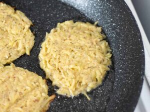 Potato pancakes in a frying pan.