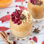 Pumpkin smoothie recipe - healthy fall drink a glass topped with pomegranate seeds, chopped walnuts, banana and star anise.