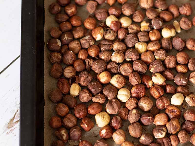 Roasted hazelnuts in a baking sheet.