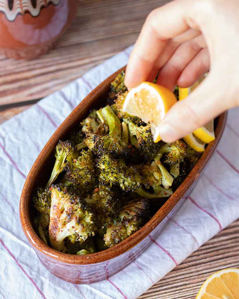 Delicious and crisp baked broccoli served with a freshly squeezed lemon juice and spicy red pepper flakes as a vegan, gluten-free side-dish or appetizer for Thanksgiving menu.