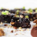 Recipe for no-bake brownies. Raw, vegan, healthy, unbaked chocolate date brownie topped with shopped walnuts and pomelo peel.