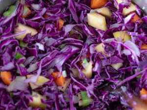 Cooking healthy vegetables in a pot for making a hearty and comforting vegan stew.