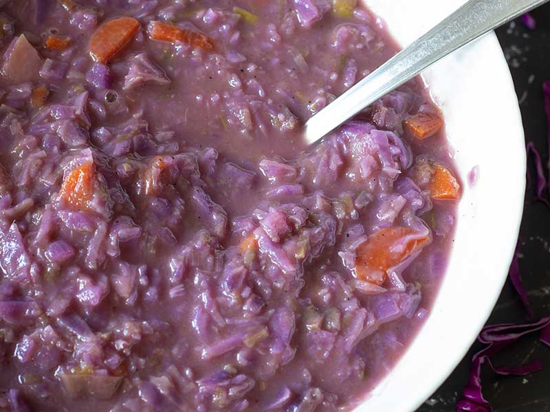 Vibrant purple vegan vegetable soup with creamy and chunky texture.