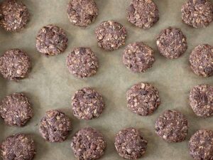 Chewy oil-free cookies on a baking sheet lined with parchment paper prepared for baking.