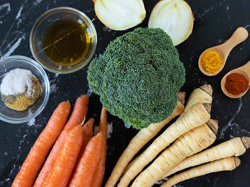 Fresh plant-based ingredients for cookin homemade carrot and parsnip soup as an vegetarian appetizer, starter, or cozy weeknight dinner.