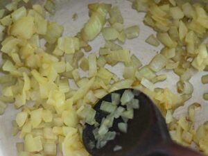 Finely diced onion in olive oil in a cooking pot.