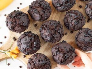 Moist and fluffy vegan-friendly banana chocolate muffins on wooden board.