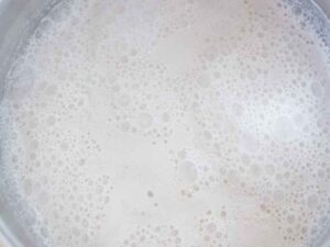 Non-dairy milk boiling in a large pot on the stove.