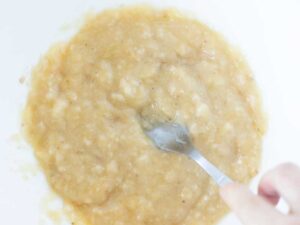 Mashed bananas in a bowl for baking homemade oatmeal cookies.