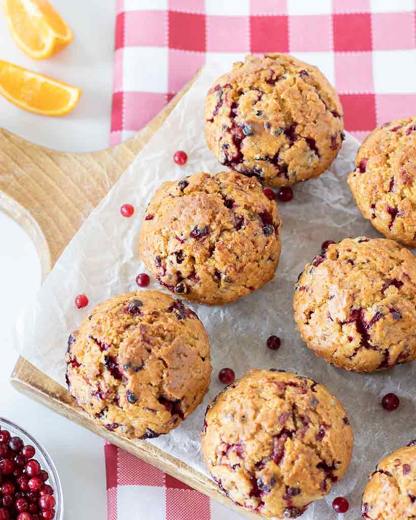 Bakery-style homemade cranberry orange muffins without eggs and yogurt on a table