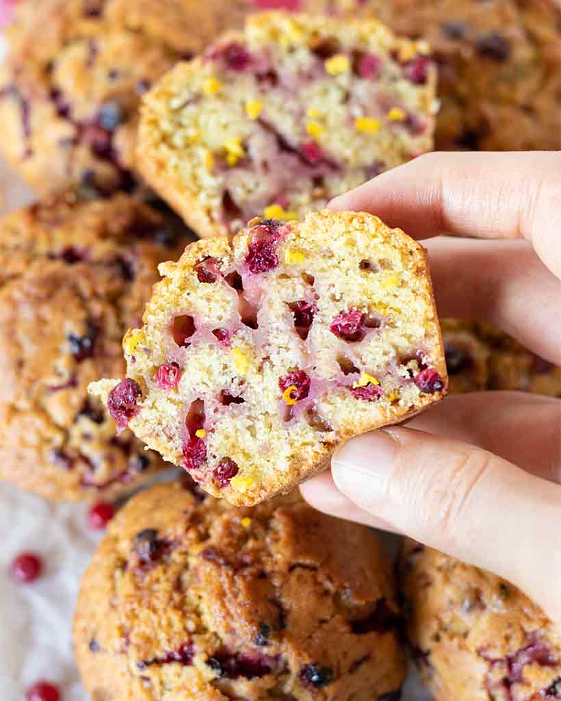 Delicious eggless cranberry muffin cut in half sprinkled with orange zest
