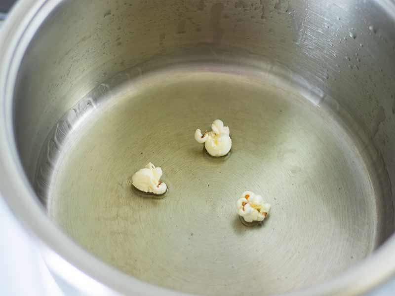 Three popped corn kernels in a pot