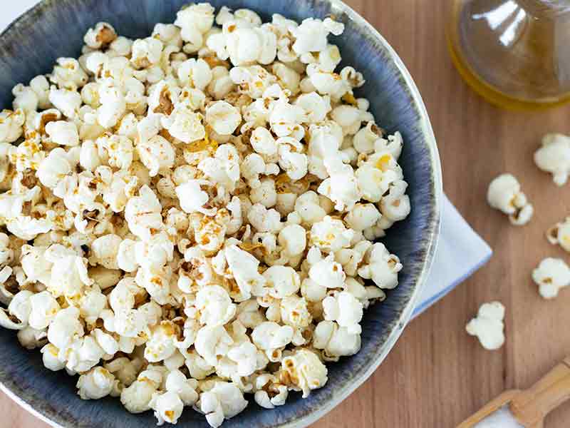 Perfect fluffy and crispy homemade popcorn in a bowl on a wooden table