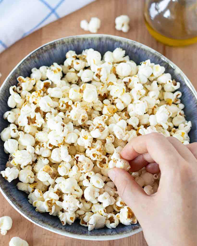 A big bowl full of homemade popcorn on the stove