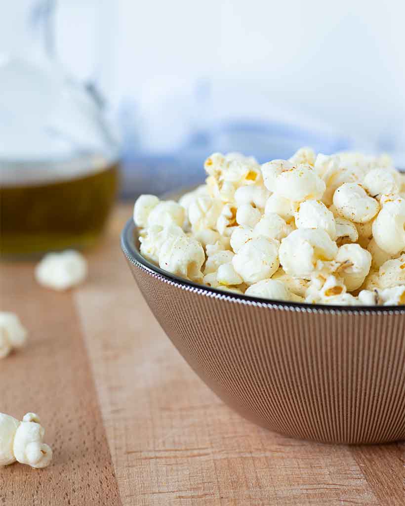 How to make stovetop popcorn that is perfect every time. A bowl full of fluffy and crunchy homemade popcorn.
