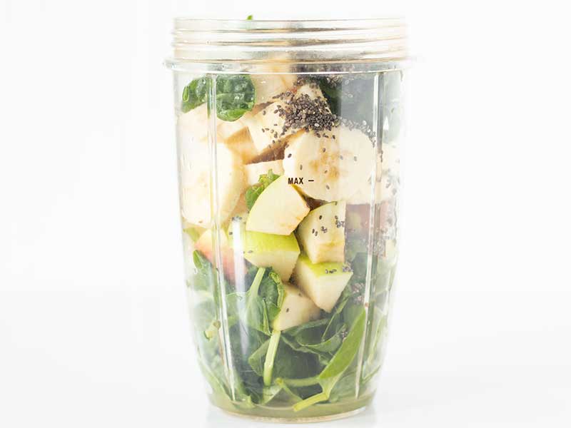 Fresh vegetables and fruits in a blender container for preparing easy and healthy green detox drink