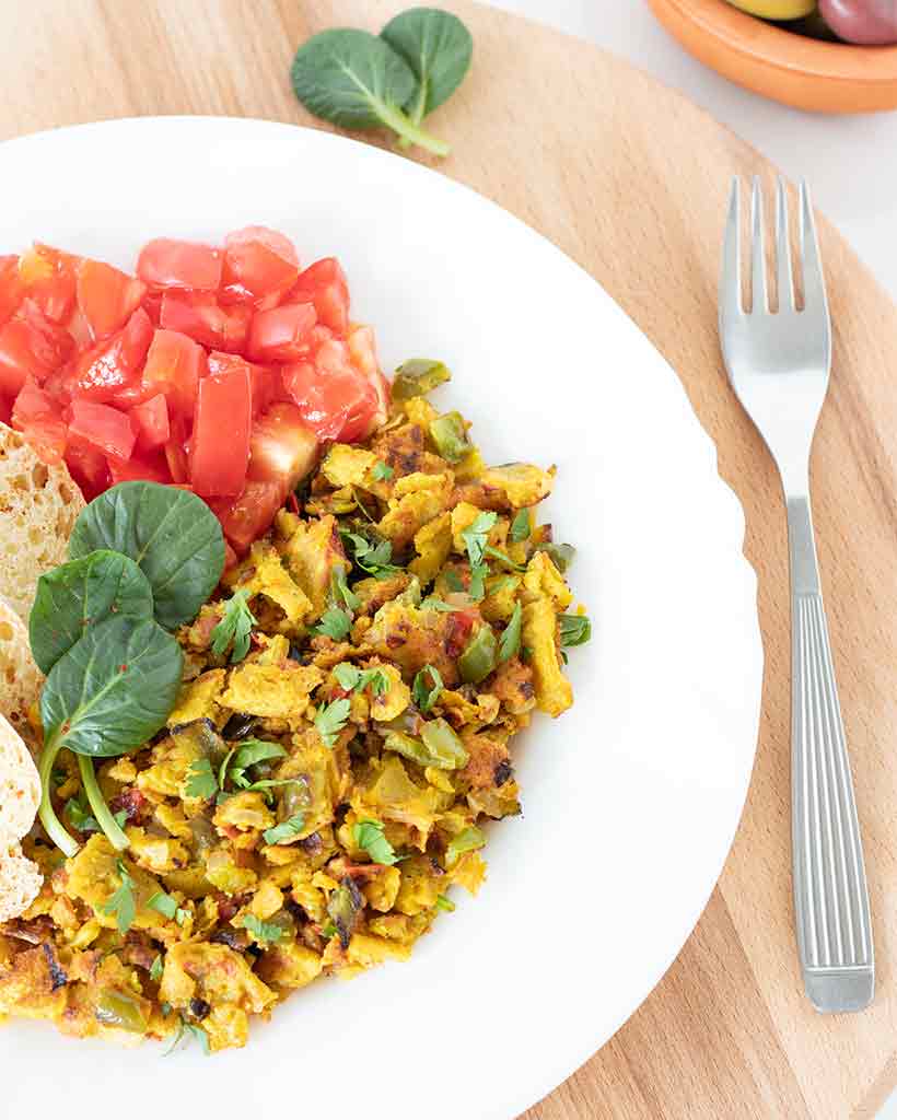 Chickpea flour scramble served with fresh parsley, tomatoes, baby spinach, and homemade bread for breakfast (no tofu, no soy)