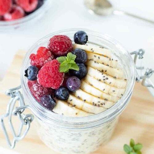 Weight loss overnight oats in a jar with raspberries, banana, blueberries, and mint