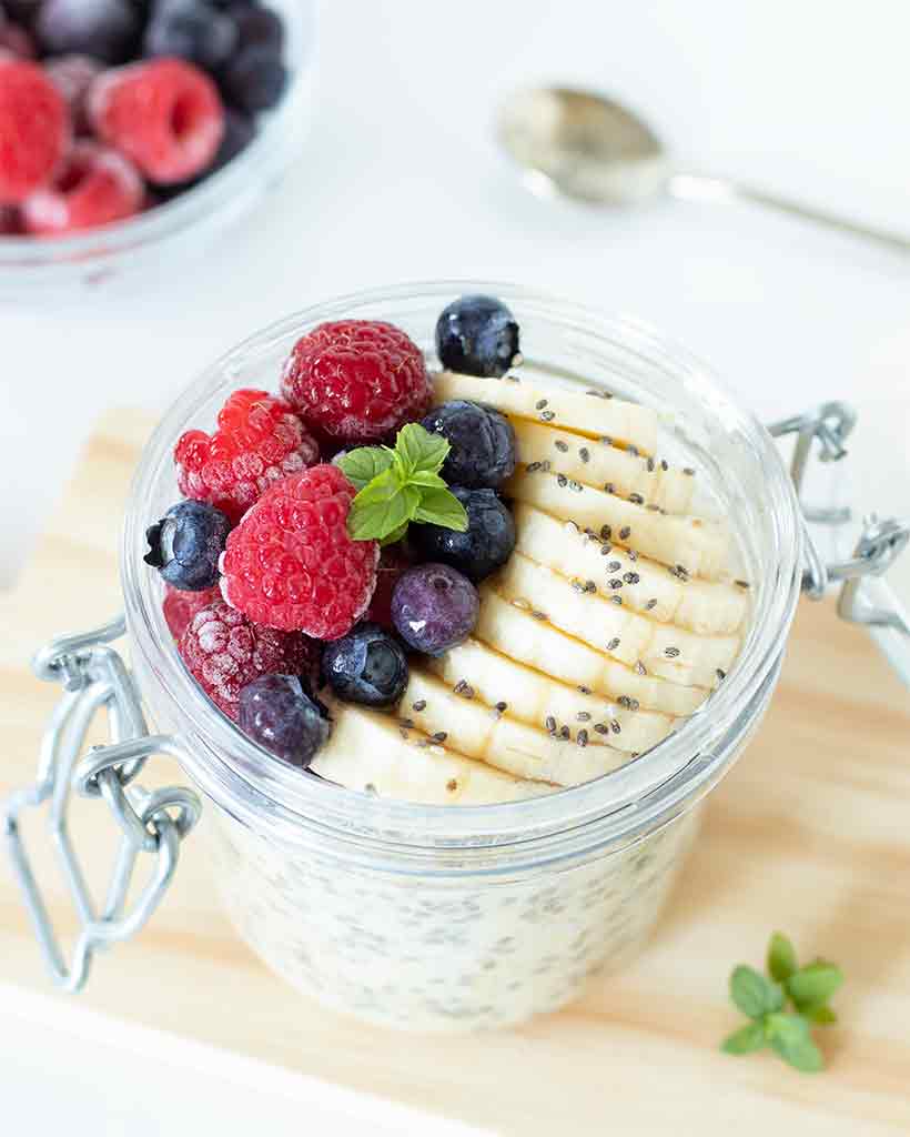 Healthy overnight oats for weight loss with frozen fruit and sliced banana.