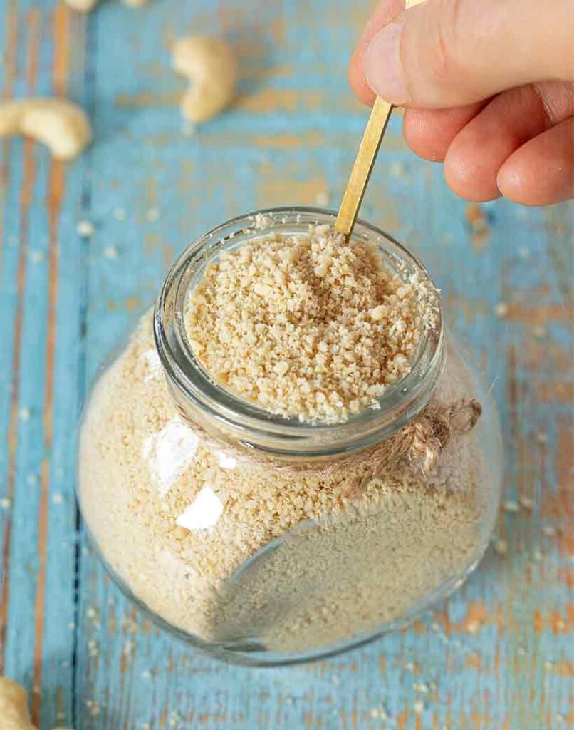 Lactose-free homemade parmesan cheese in a jar with golden spoon