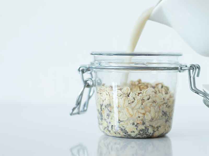Rolled oats, chia seeds, maple syrup, and dairy-free milk mixed in a jar for breakfast or brunch