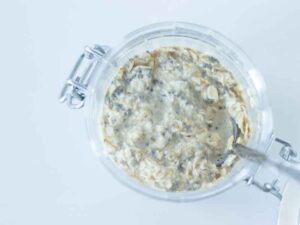 Rolled oats mixed with dairy-free milk, chia seeds, and maple syrup in a jar as an easy make-ahead breakfast meal prep