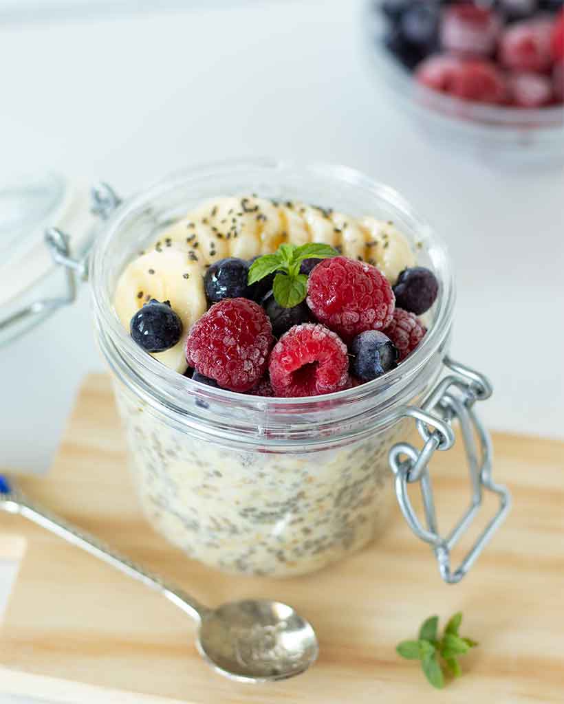 Easy vegan weight-loss overnight oats on a wooden board with spoon and fruit