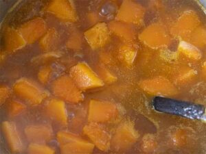 Healthy soup simmering in a large cooking pot on the stove
