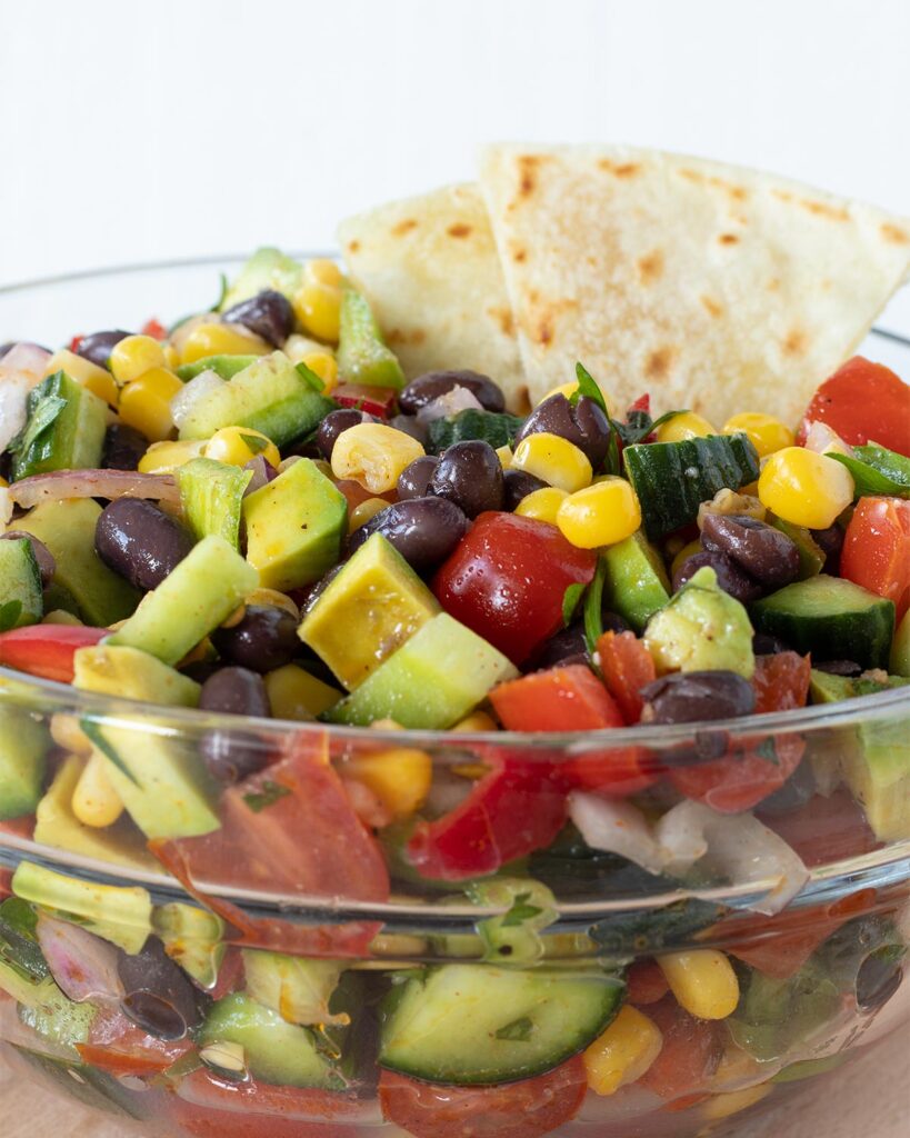 Fresh and healthy Mediterranean vegan salad in a bowl with toritilla slices