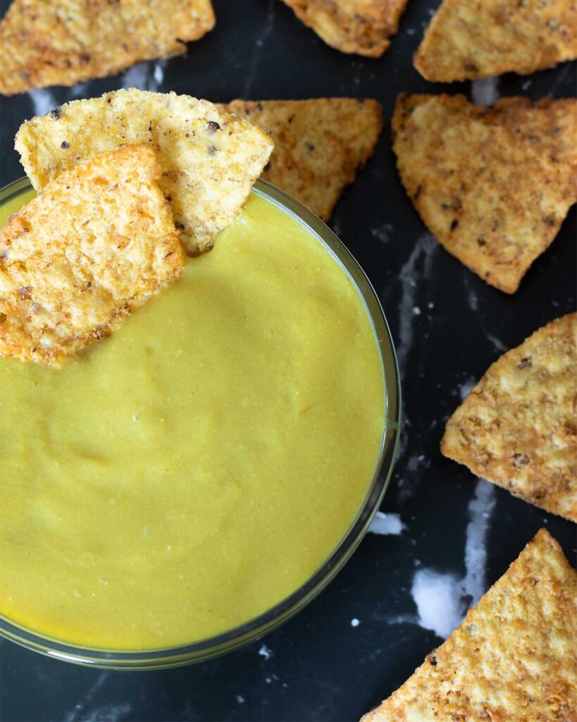 Vegan nooch spread in a bowl (no potatoes, no cashews) with corn chips