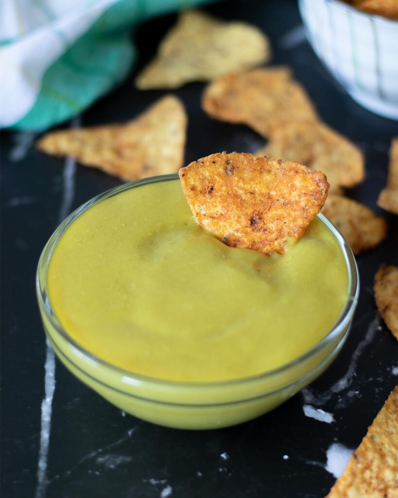 Creamy plant-based cheese sauce made without cashews in a bowl with corn chips