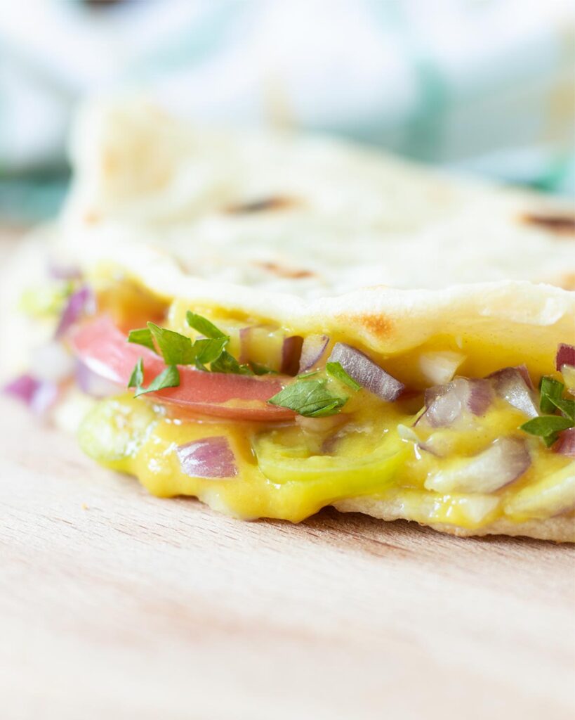 Homemade tortilla filled with dairy-free cheese sauce and fresh vegetables