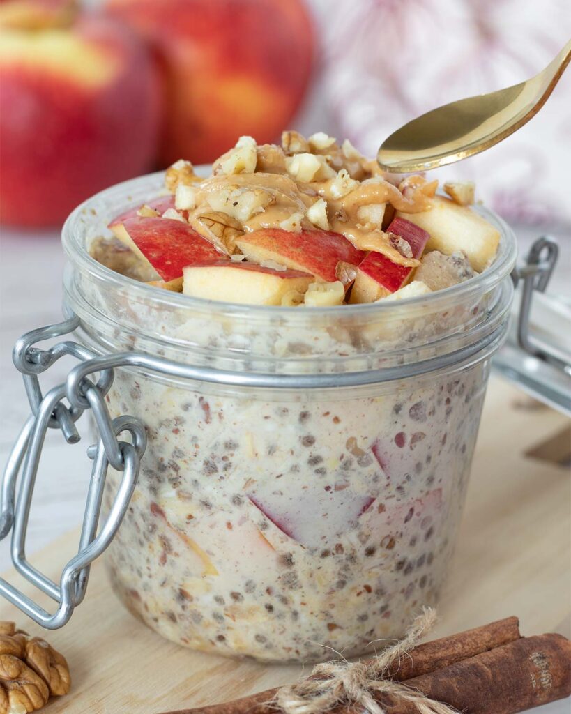 Vegan apple overnight oats (no yogurt) in a jar topped with peanut butter, diced apples, and walnut for breakfast